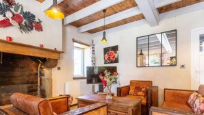 Un salón acogedor con chimenea, muebles de madera y obras de arte en las paredes.