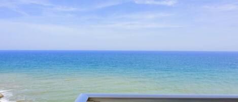 A balcony with a view of the ocean.