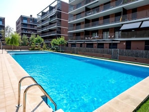 Een modern appartementencomplex met een zwembad.
