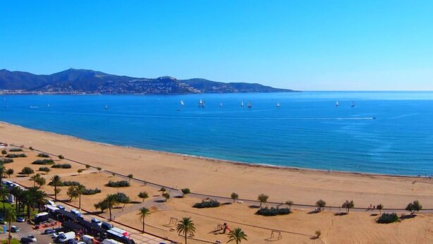 A beach with a clear view of the ocean, a sandy shore, and a distant mountain range. - Vacation home Luna by Interhome (Empuriabrava)