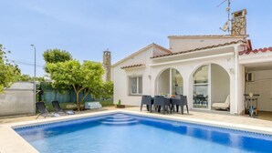 A house with a swimming pool, outdoor seating, and a stone chimney. - Vacation home Luna by Interhome (Empuriabrava)
