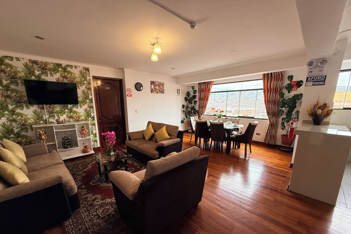 A living room with a sofa, armchairs, a coffee table, and a dining area with a table and chairs.