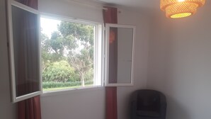 Une chambre à coucher avec un lit, une fenêtre et une chaise.