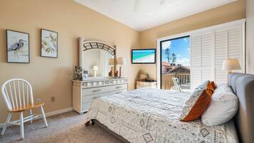 A bedroom with a bed, a chair, a dresser, a mirror, and artwork on the walls.