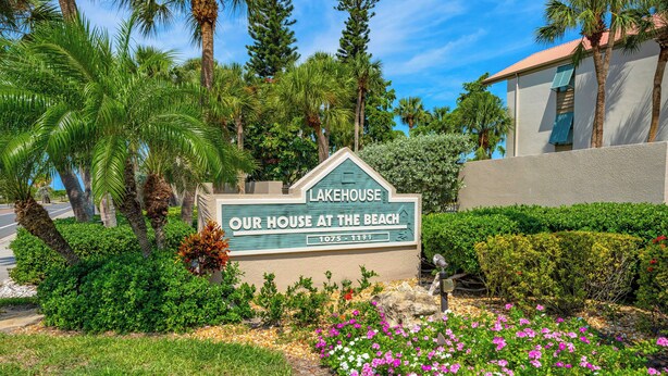 A sign for 'Lakehouse Our House at the Beach' with a landscaped garden in front. - Our House Lake House by Beachside Mgt (Siesta Key)