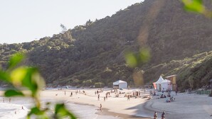 Una playa con gente, tiendas de campaña y una torre de salvavidas.