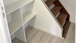 Een houten trap met witte muren en een inbouwplank.