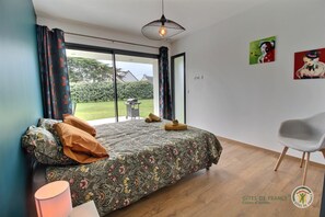 Un dormitorio con una cama grande, una silla y vistas al exterior.