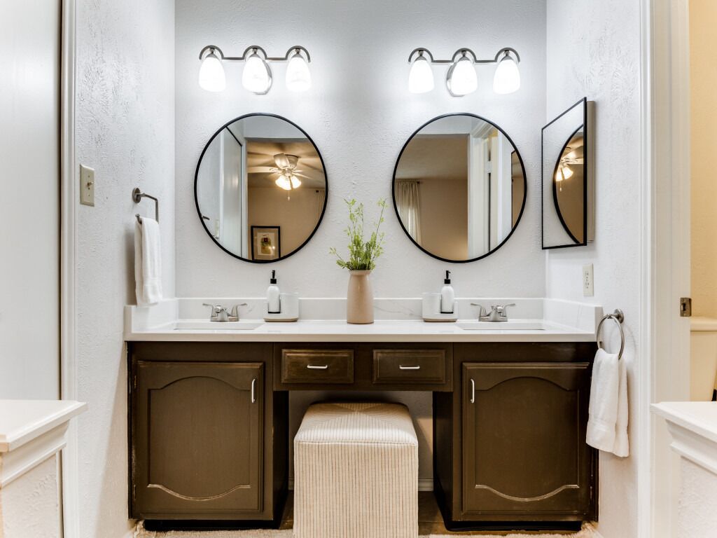 A bathroom with two sinks, a mirror, and a towel rack.