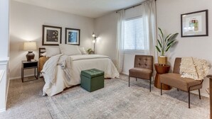 A bedroom with a bed, a chair, a side table, a lamp, a plant, and a ceiling fan. - Escape to Olivia's Hideaway in Allen! Close  to shopping,Eat, and entertainment (Allen)