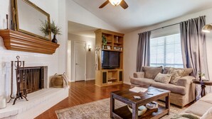 A living room with a fireplace, a television, a ceiling fan, and a sofa. - Escape to Olivia's Hideaway in Allen! Close  to shopping,Eat, and entertainment (Allen)