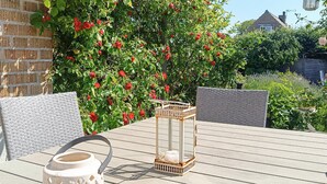 A patio with wicker furniture, a lantern, and a potted plant. - Stunning home in Höganäs with WiFi (Höganäs)