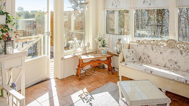 A bright room with a sofa, a table, and a window overlooking a garden. - Stunning home in Höganäs with WiFi (Höganäs)