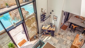 Un interior moderno con piscina de cristal, una escalera y un área de comedor.