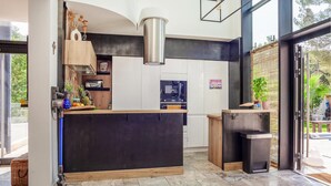 Una cocina moderna con una isla central, horno empotrado y un refrigerador pequeño.