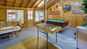 Un ambiente accogliente con un tavolo da calcio, un biliardo e un divano.