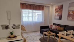 Una sala de estar moderna con un sofá, una mesa de centro y un comedor con mesa y sillas.