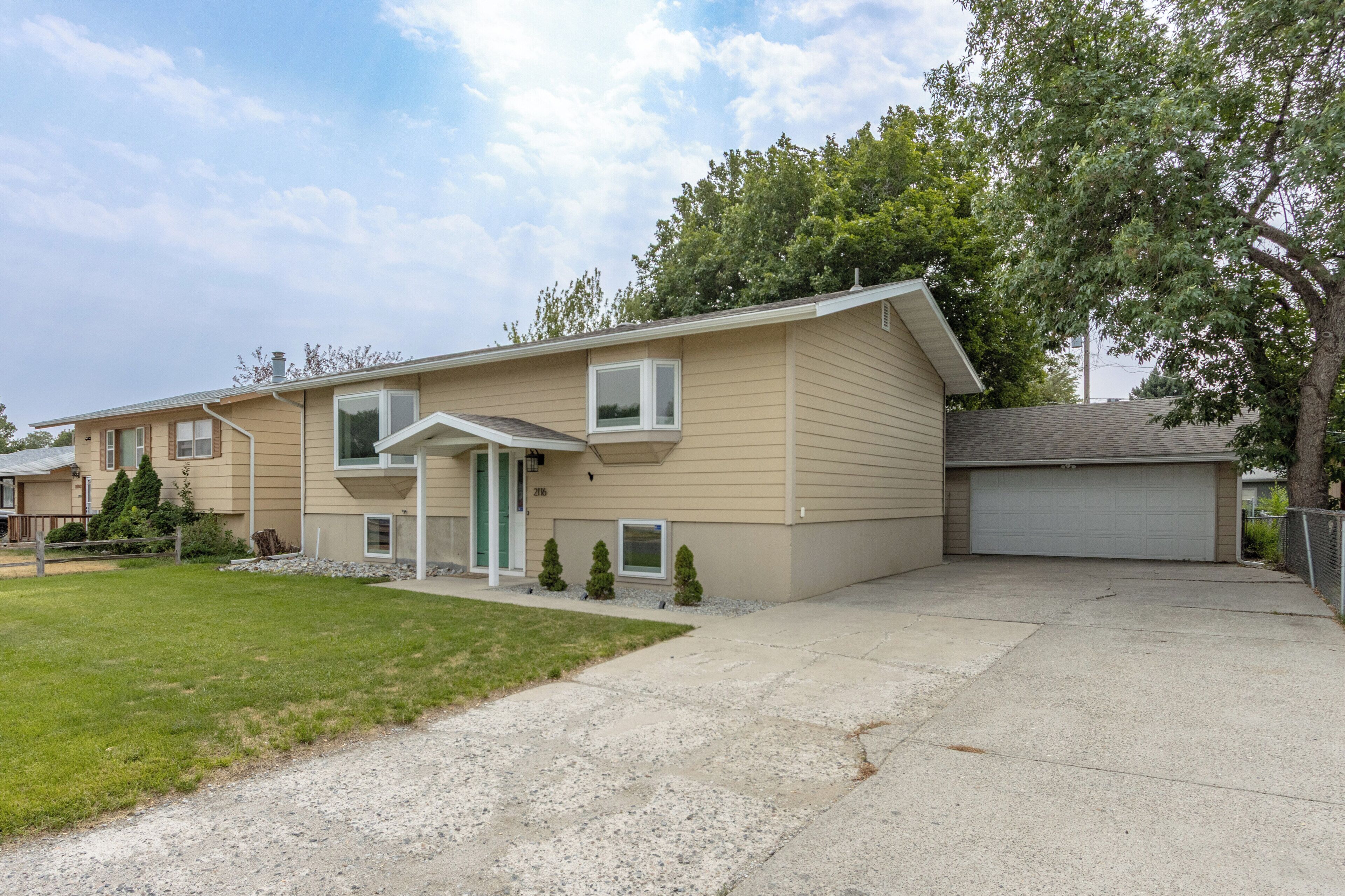 A two-story residential building with a front entrance, a garage, and a well-maintained lawn.