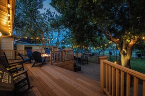 An outdoor deck with wooden flooring, outdoor furniture, and string lights. - Centrally located, huge shaded patio with fire pit! Entire place to yourself! (Billings)