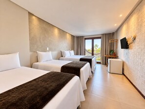 Habitación de hotel con dos camas, un escritorio pequeño, un televisor y un balcón con vistas.