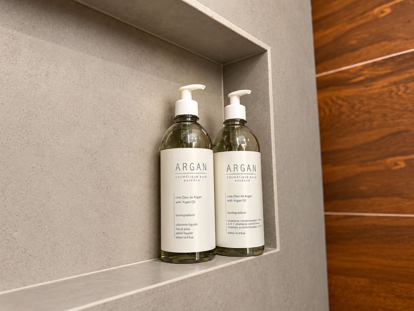 Two bottles of Argan oil-based shampoo in a shelf.