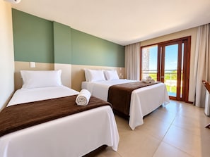 A hotel room with two beds, a balcony with curtains, and a view of the outdoors. - HOTEL ICARAI BEACH (Amontada)