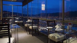 A restaurant with a panoramic city view at dusk. - Apu Mountain Lodge (Cusco)