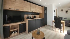 A modern kitchen with wooden cabinets, a built-in oven, and a black countertop.