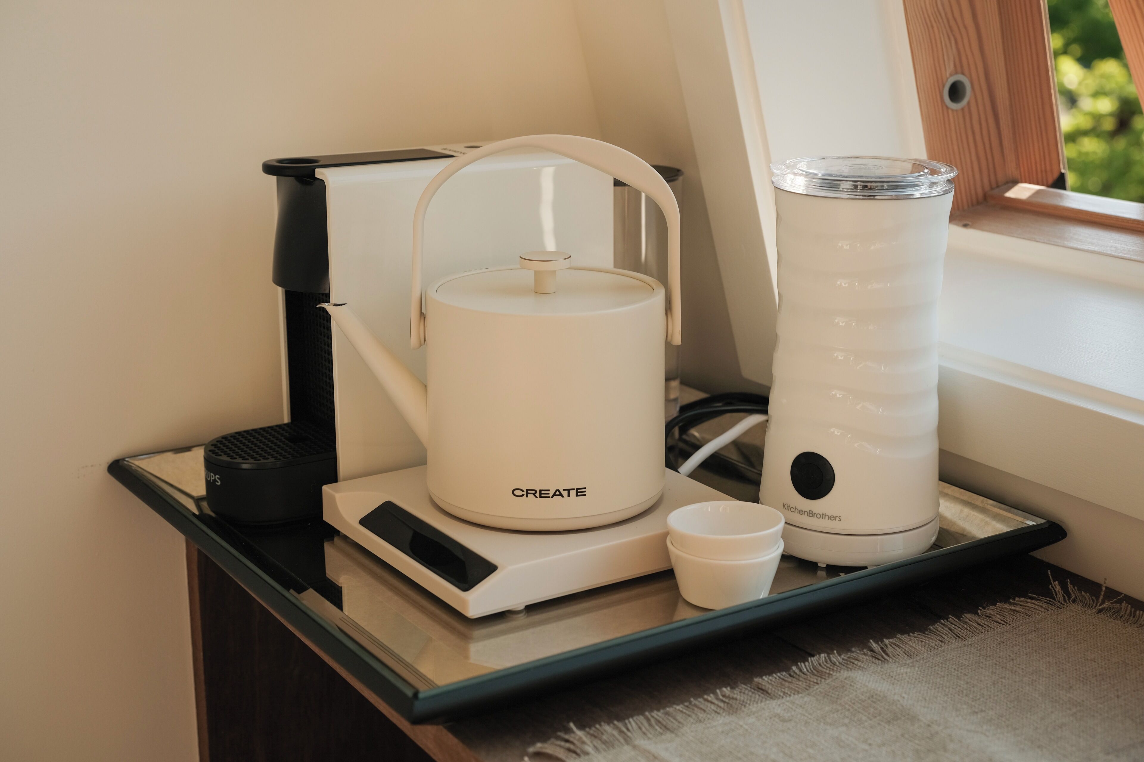 A kitchen counter with a coffee maker, a kettle, and a blender.