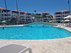 A swimming pool with clear blue water, surrounded by lounge chairs and umbrellas. - I 203, Stanza Mare, 2 bed, Private Beach, Bavaro , Punta Cana, 24 hrs security
(Bavaro)