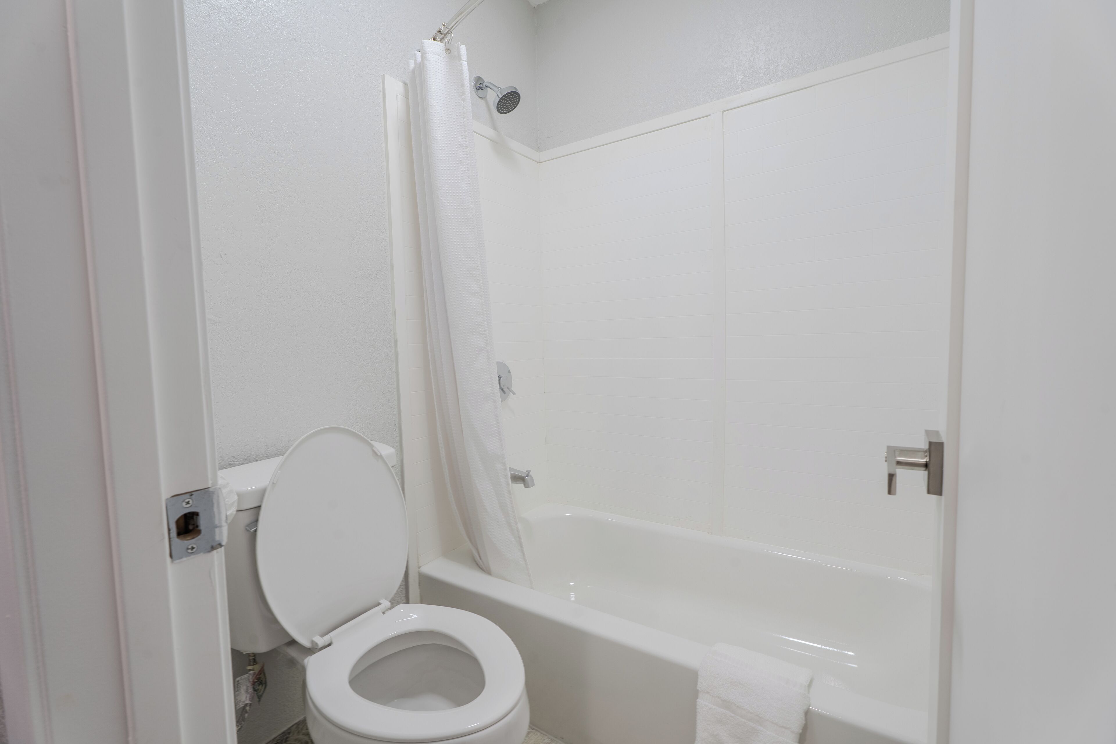 A bathroom with a toilet, a bathtub, and a shower curtain.