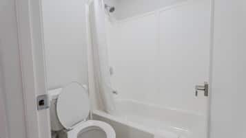 Un baño con inodoro, bañera y cortina de ducha.