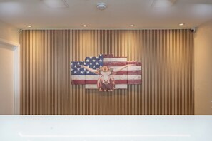 Un mur composé de lattes de bois verticales et orné d’une fresque représentant une vache, le tout dans un style inspiré du drapeau américain.
