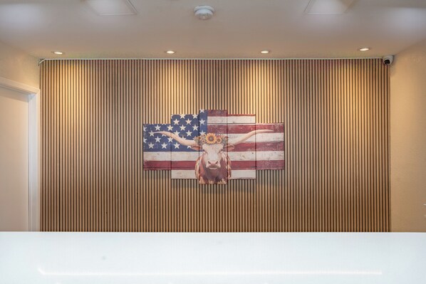 A wall with vertical wooden slats and a mural of a cow with an American flag design. - Executive Inn of Arlington, Near AT&T Stadium (Arlington)