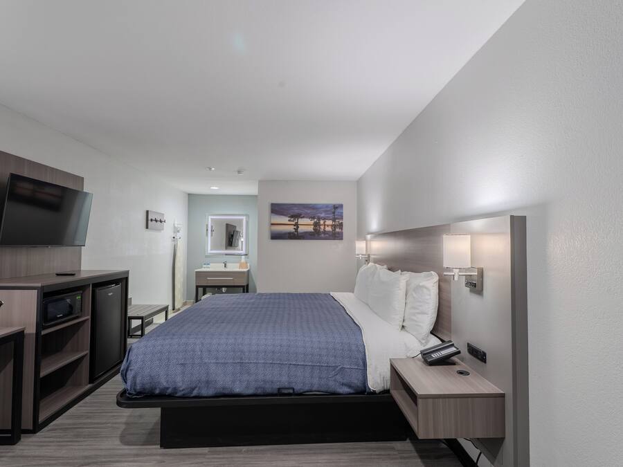 Una habitación de hotel moderna con cama, escritorio y televisión.