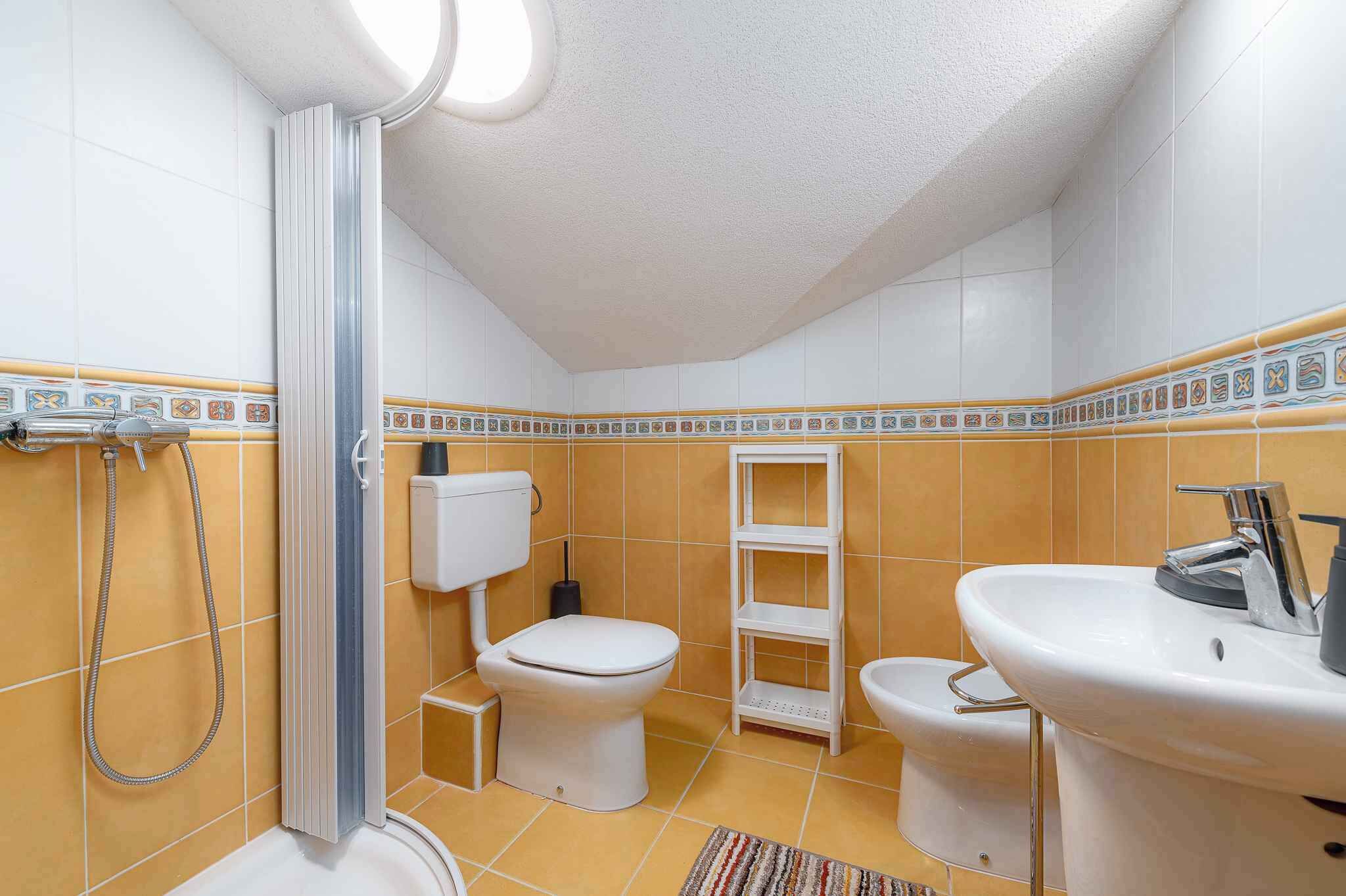 A bathroom with a shower, toilet, and sink.