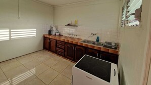 Une cuisine équipée d’une cuisinière, d’un évier, de placards et d’un pare-feu en carreaux.