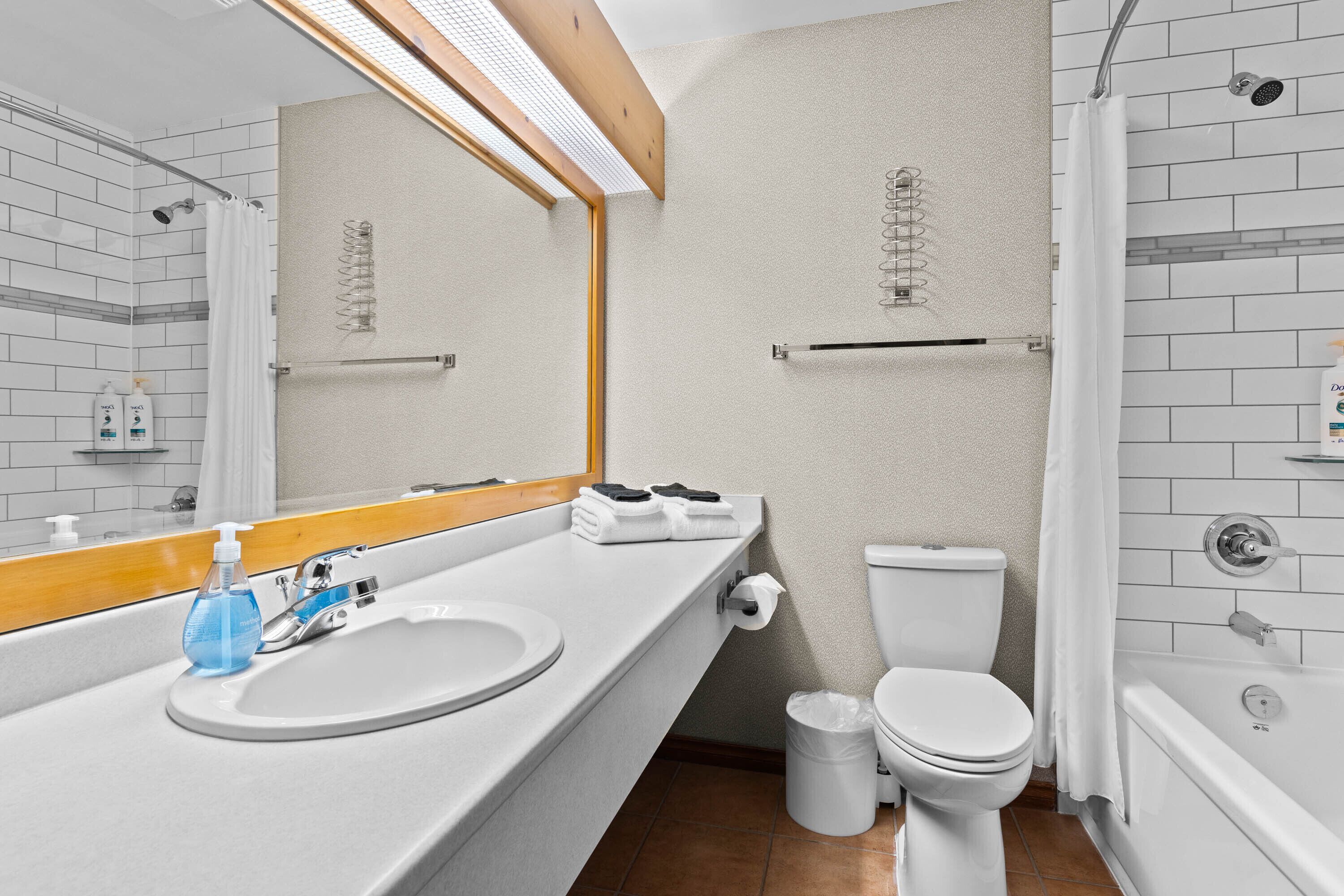 Une salle de bain moderne avec un lavabo blanc, un miroir et des toilettes.