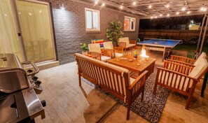 A cozy indoor space with a ping pong table, wooden furniture, and a barbecue grill. - Retro Rooms: Ping-Pong, Fire-Pit, Game Room, Families + Dogs + Fenced Yard (Arvada)