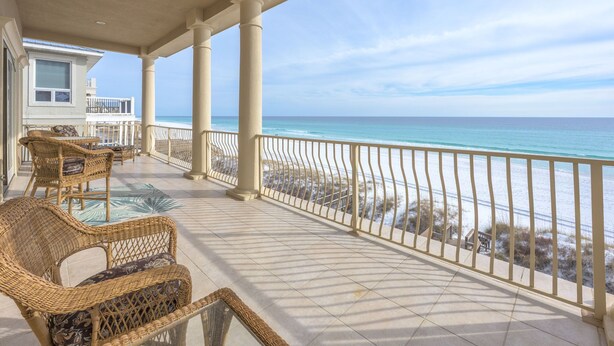 A covered balcony with wicker furniture and a view of the ocean. - Gulf Paradise * Golf Cart & Beach Chair Set * Gulf Front * Salt Water Vacations (Miramar Beach)