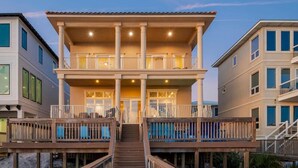 A multi-story beachfront property with balconies, a covered deck, and a staircase leading to the upper levels. - Gulf Paradise * Golf Cart & Beach Chair Set * Gulf Front * Salt Water Vacations (Miramar Beach)