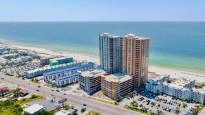 A coastal hotel complex with multiple buildings, a beach, and a road. - Phoenix Gulf Tower 1704 | Spacious, luxurious, Newest OBA development! (Orange Beach)