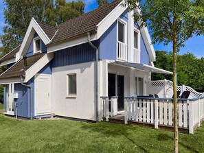 Ein zweistöckiges Haus mit einer Veranda und einem eingezäunten Deck.