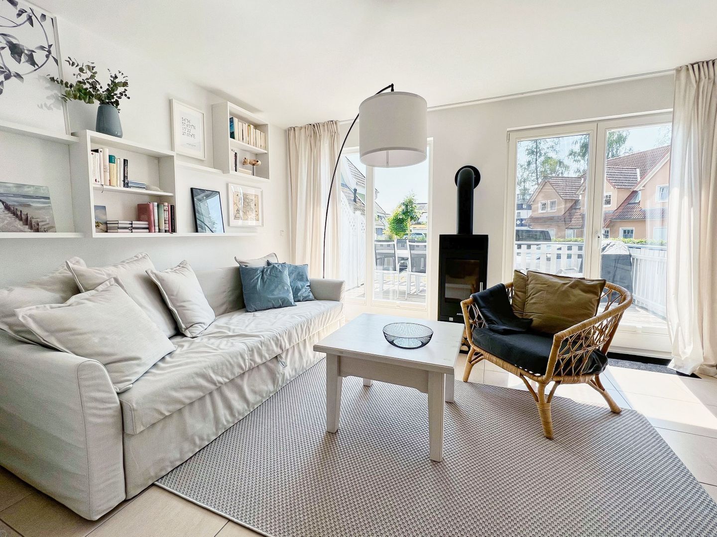 A living room with a sofa, a chair, a coffee table, a fireplace, and a view of the outside.