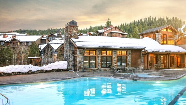 A resort with a swimming pool, stone and wood buildings, and a snowy landscape. - NorthStar Lodge at Lake Tahoe in walking distance to ski lifts! (Truckee)