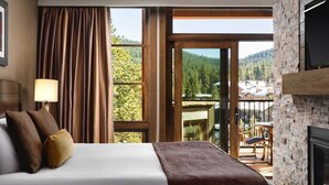 A hotel room with a bed, a fireplace, a balcony with a view of the mountains, and framed pictures on the wall. - NorthStar Lodge at Lake Tahoe in walking distance to ski lifts! (Truckee)