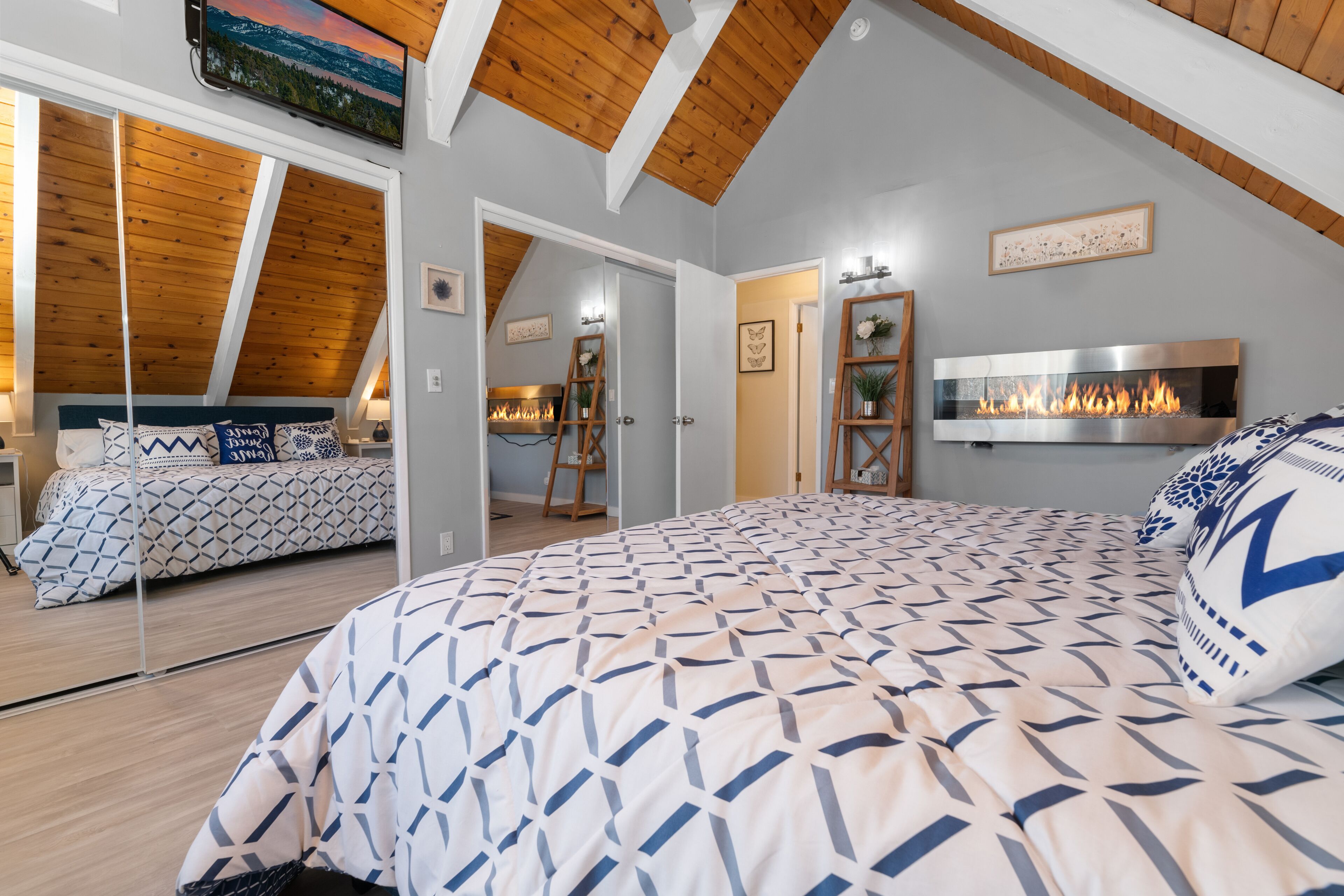 Quarto com uma cama grande, lareira e um mezanino com área de dormir.