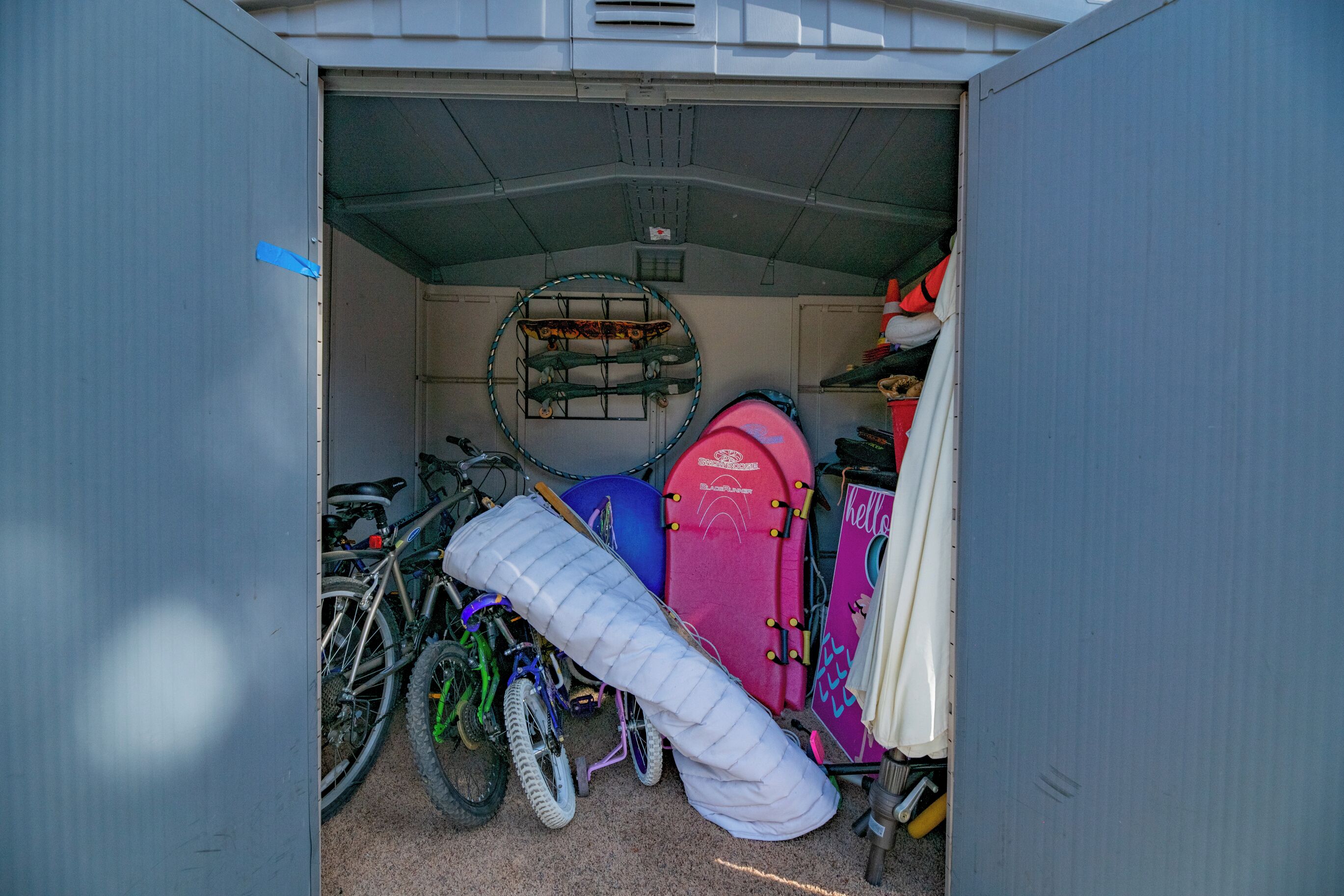 Un módulo de almacenamiento compacto con bicicletas, saco de dormir y una tabla de surf.