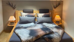 Ein Schlafzimmer mit Dachfenster, einem Holzkopfende und zwei Nachttischlampen.