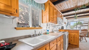 Una cocina con armarios de madera, un lavamanos doble y una estufa.